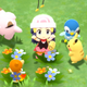 A Pokémon trainer cheers in a field while surrounded by Pokémon.